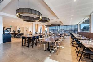 a dining room with tables and chairs and windows at Ingot Hotel Perth, Ascend Hotel Collection in Perth