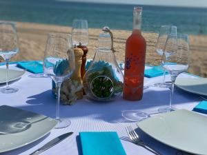 a table with glasses and a bottle of wine on the beach at Boutique Citadel in Eforie Nord