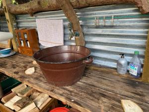 um balde sentado em cima de uma mesa de madeira em The Hobbit House and Secret Garden em Taunton