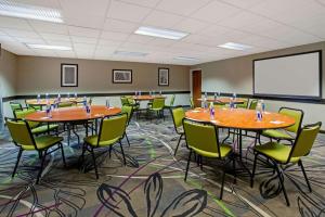 a conference room with tables and chairs and a screen at La Quinta Inn & Suites by Wyndham Detroit Metro Airport in Romulus