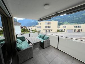 Un balcón con 2 sillas y una mesa con vistas. en Great new apartment surrounded by nature., en Schattdorf