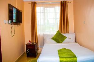 een kleine slaapkamer met een bed en een raam bij Luna hotel in Nakuru