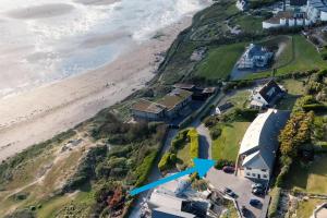 an aerial view of a house next to the beach at White Lodge - Coast Hideaways in Mawgan Porth