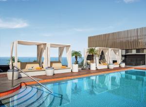 a swimming pool with chairs and a gazebo at Hyatt Centric Juhu Mumbai in Mumbai