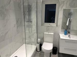 a bathroom with a shower and a toilet and a sink at Stunning City Centre Apartments in Cardiff