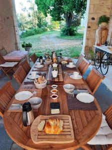 een lange houten tafel met eten erop bij Chambre d'hôtes "Au bord de Loire" in La Marche