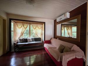 a living room with a couch and a mirror at Casa Xixo Escultura in Gramado