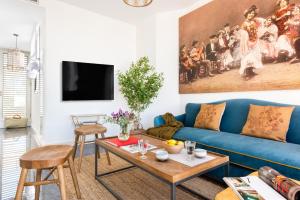 uma sala de estar com um sofá azul e uma mesa em Casas De Adriano em Sevilha