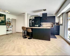 a kitchen with blue cabinets and a wooden floor at Appartement centre de Paris avec Parking et terrasses in Paris