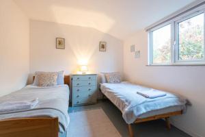 two twin beds in a room with a window at The Chalet in Fort Augustus
