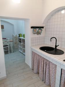 - une cuisine avec un évier et un comptoir dans l'établissement Albero di giada, à Massafra