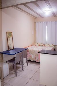Habitación con mesa azul y cama en Loft Pé na Areia, en Arraial do Cabo