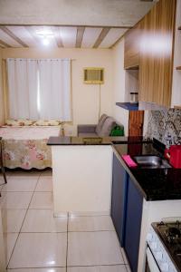 una pequeña cocina con una habitación con cama en Loft Pé na Areia, en Arraial do Cabo