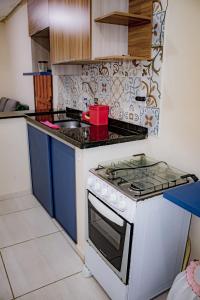 una cucina con piano cottura bianco e lavandino di Loft Pé na Areia ad Arraial do Cabo