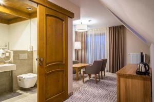 a hotel room with a toilet and a table at Sichlański Dworek & SPA in Murzasichle