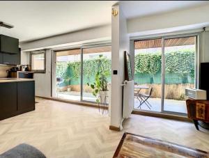 a living room with a large window and a kitchen at Appartement centre de Paris avec Parking et terrasses in Paris