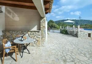 a stone patio with a table and chairs next to a building at Owl Booking Villa Sedes - Dive Into Nature in Campanet