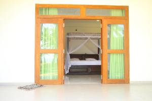 Drzwi do sypialni z łóżkiem w obiekcie Lihini Beach Villa w mieście Induruwa
