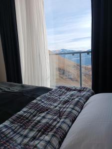 a bedroom with a bed and a window with a view at Apartment with a great view 544 in Gudauri