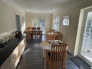 a kitchen and dining room with tables and chairs at Oakhurst Gatwick and holiday parking five pounds per day and transport between six am and eleven pm in Crawley