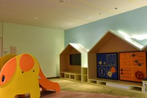 a childs room with a toy house and a tv at Timurbay Beach Resort Balok Kuantan in Kampung Sungai Karang
