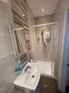 a white bathroom with a sink and a shower at Oakhurst Gatwick B&B in Crawley