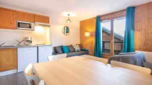 eine Küche und ein Esszimmer mit einem Tisch in einem Zimmer in der Unterkunft Les Huskies- 48- Refait a Neuf- 6 pers in Saint-Sorlin-dʼArves