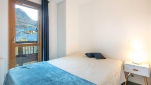 ein Schlafzimmer mit einem Bett und einem Fenster mit Aussicht in der Unterkunft Les Huskies- 48- Refait a Neuf- 6 pers in Saint-Sorlin-dʼArves