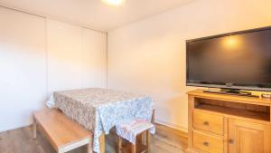 a room with a flat screen tv and a table at Les Tetras- 60- Appart Renove - 8 pers in Saint-Sorlin-dʼArves