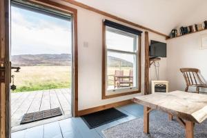 a room with a table and a sliding glass door at The Field House in Fort Augustus