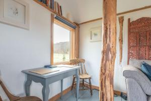 a desk in a room with a window and a chair at The Field House in Fort Augustus