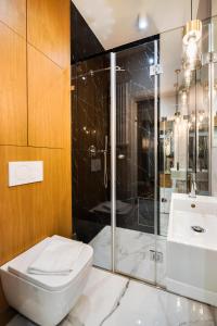 a bathroom with a shower and a toilet and a sink at MOSTOWA Abdank Old Town Apartment in Warsaw