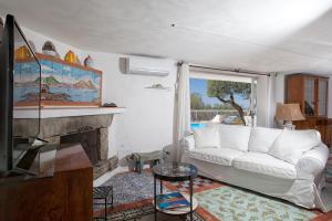 a living room with a white couch and a fireplace at Villa Venus in Penisola sorrentina in Massa Lubrense