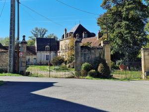een oud huis met een hek en een hek bij Chambre d'hôtes "Au bord de Loire" in La Marche