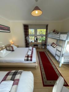 a bedroom with two beds and a living room with a ladder at Oakhurst Gatwick B&B in Crawley