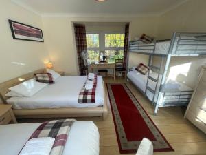 1 Schlafzimmer mit 2 Etagenbetten und einem Schreibtisch in der Unterkunft Oakhurst Gatwick B&B in Crawley