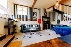 a living room with blue couches and a piano at The Wellie Stern a unique home recapturing history in Harwich