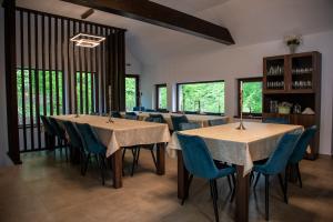 - une salle à manger avec des tables, des chaises et des fenêtres dans l'établissement Pensiunea Black Mountain, à Baia Sprie