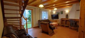 a living room with a couch and a television at Domek na Malinowej in Szczyrk