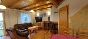 a living room with a leather couch and a television at Domek na Malinowej in Szczyrk