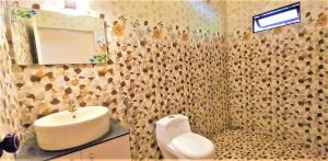 een badkamer met een wastafel, een toilet en een spiegel bij Bella Beach Villa in Mararikulam