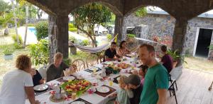 un grupo de personas sentadas en una mesa comiendo comida en Tibambari, en Bouchon