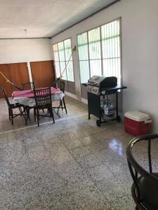 an empty room with a grill and a table and chairs at Guanica Malecon Bay House in a comfortable and quiet place in Guanica