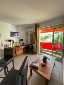 a living room with a table and chairs and a window at Charmant 2 Pièces Vue sur Mer et MONTE-CARLO à ROQUEBRUNE CAP MARTIN in Roquebrune-Cap-Martin