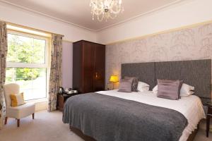 a bedroom with a large bed and a chandelier at Ees Wyke Country House in Near Sawrey