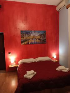 Serravalle Pistoiese的住宿－Hotel Alba Serravalle，红色卧室配有带2条毛巾的床