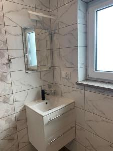 a white bathroom with a sink and a mirror at Na wilczym szlaku in Ustrzyki Dolne