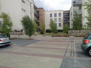 a parking lot with two cars parked in front of buildings at Apartament Bażantowo in Katowice