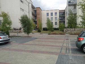 a parking lot with two cars parked in front of buildings at Apartament Bażantowo z parkingiem in Katowice