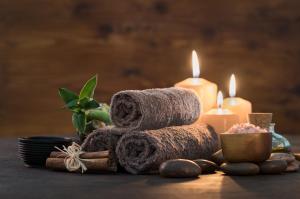 einen Haufen Handtücher und Kerzen auf dem Tisch in der Unterkunft DAS HUDEWALD Hotel & Resort in Ückeritz